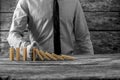 Greyscale image of businessman stopping falling dominos