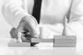 Greyscale image of businessman supporting chess pieces Royalty Free Stock Photo