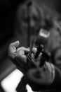 Greyscale image of elderly male musician with dirty nails playing a violin Royalty Free Stock Photo