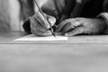 Greyscale image of a senior man doing calligraphy Royalty Free Stock Photo