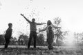 Greyscale image of young family playing with autumn leaves stand Royalty Free Stock Photo