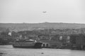 Greyscale of a port with numerous building on the background and a big ferry in the front in Valleta