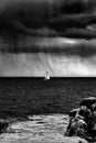 Greyscale of a sailing ship on the sea under a dark cloudy sky during daytime Royalty Free Stock Photo