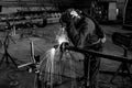 Greyscale shot of a person welding at a construction site