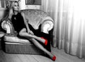 greystyle picture of Adorable hot blonde woman in long black dress and red high heels Royalty Free Stock Photo