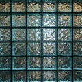A grid of glass blocks forms a textured wall. Each block is square and slightly Royalty Free Stock Photo