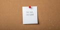 A grid paper note pinned with a red pin displaying the phrase SO FAR and SO GOOD on a corkboard Royalty Free Stock Photo
