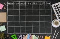 Grid timetable schedule with stationery on black chalkboard back