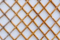 Grid of wooden fence against old white wall Royalty Free Stock Photo