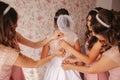 Gridesmaids help bride at her home. Morning of beaufiful bride. Girl`s hepl bride look wonderful Royalty Free Stock Photo