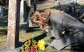 Grief-stricken lady with flowers at grave Royalty Free Stock Photo