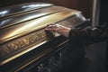 Grieving woman's hand touching a coffin
