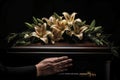 Grieving woman's hand touching a coffin