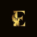 Griffin silhouette inside gold letter E. Heraldic symbol beast ancient mythology or fantasy. Creative design elements for logotype