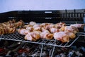 Grill bacon roll in a BBQ with coal. Marinated meat in metal net during garden party. Summer barbecue outdoors. Hot embers to cook Royalty Free Stock Photo
