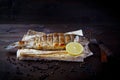 Grill dishes, seafood or fish and pita for the restaurant menu. Wooden background. Sea bass grilled pita bread and lemon Royalty Free Stock Photo