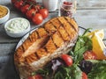 Grill fish steak salmon with fresh salad and tomatoes, white sauce, dijon mustard, top view Royalty Free Stock Photo