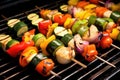 grill light highlighting colourful vegetable skewers