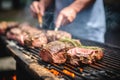 grill master flipping herb-rubbed beef steaks on backyard barbecue