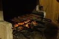 Grill with meat on a flaming charcoal grill with open fire at night. Concept of summer grilling, barbecue, bbq and party. Black co Royalty Free Stock Photo