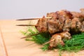 Grill meat on a sticks with green on wooden plate Royalty Free Stock Photo