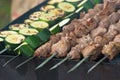 Grill season, meat and zucchini skewers on bbq, open kitchen Royalty Free Stock Photo