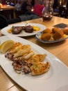 Grill squid on white plate with other tapas Royalty Free Stock Photo