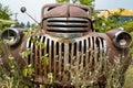 The grille and broken headlights on a 1943 Chevy truck in a junkyard in Idaho, USA - July 26,2021