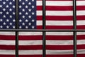 The grille of the detention cell on the background of the American flag. Concept: court session, jury trial, sentencing.