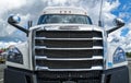 The grille and windshield of a white Freightliner Cascadia semi truck parked in a rest stop on Interstate 90 in Washington, USA Royalty Free Stock Photo