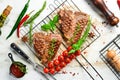 Grilled aged T-bone steak with rosemary on a white wooden background. Top view. Rustic style