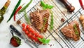 Grilled aged T-bone steak with rosemary on a white wooden background. Top view. Rustic style