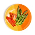 Grilled asparagus and peppers on a yellow-orange plate. White isolated background. The concept of proper nutrition. Flat lay Royalty Free Stock Photo