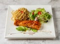 grilled atlantic salmon fish with aglio pasta and salad served in dish isolated grey background top view singapore fast food Royalty Free Stock Photo