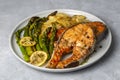 Grilled, baked salmon served on a plate with asparagus and potatoes
