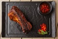 Grilled and barbecue hot pork ribs with hot chilli pepper and hot sauce on black stone background. Isolated. Dish for Royalty Free Stock Photo