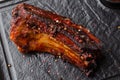 Grilled and barbecue hot pork ribs with hot chilli pepper and hot sauce on black stone background. Isolated. Dish for Royalty Free Stock Photo