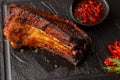 Grilled and barbecue hot pork ribs with hot chilli pepper and hot sauce on black stone background. Isolated. Dish for Royalty Free Stock Photo