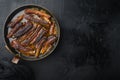 Grilled barbecue pork ribs, in frying cast iron pan, on black stone background, top view flat lay, with copy space for text Royalty Free Stock Photo