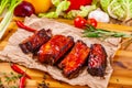 Grilled barbecue pork ribs with spices and herbs on wooden board Royalty Free Stock Photo