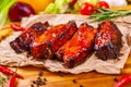 Grilled barbecue pork ribs with spices and herbs on wooden board Royalty Free Stock Photo