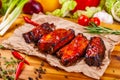 Grilled barbecue pork ribs with spices and herbs on wooden board Royalty Free Stock Photo
