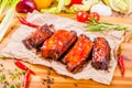 Grilled barbecue pork ribs with spices and herbs on wooden board Royalty Free Stock Photo