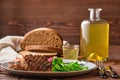 Grilled beef cutlet with fresh salad, brown bread and moonshine on wooden table Royalty Free Stock Photo