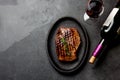 Grilled beef steak on black cast iron plate with red wine. Background with copy space. Barbecue, bbq meat beef tenderloin. Top vie Royalty Free Stock Photo