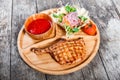 Grilled beef steak on bone, fresh salad, grilled vegetables and tomato sauce on cutting board on wooden background Royalty Free Stock Photo