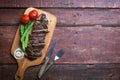 Grilled beef steak on a cooking board and wooden rustic background Royalty Free Stock Photo