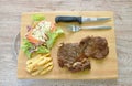 Grilled beef steak dressing barbecue sauce  with French fries and salad on chopping block Royalty Free Stock Photo