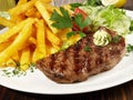 Grilled Beef Steak with French Fries and Herb Butter Royalty Free Stock Photo