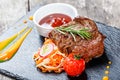 Grilled beef steak with fresh salad and bbq sauce on stone slate background on wooden background close up Royalty Free Stock Photo